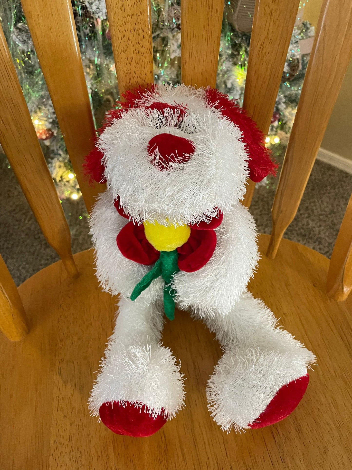 Red and white fluffy puppy dog holding flower stuffed animal plush toy